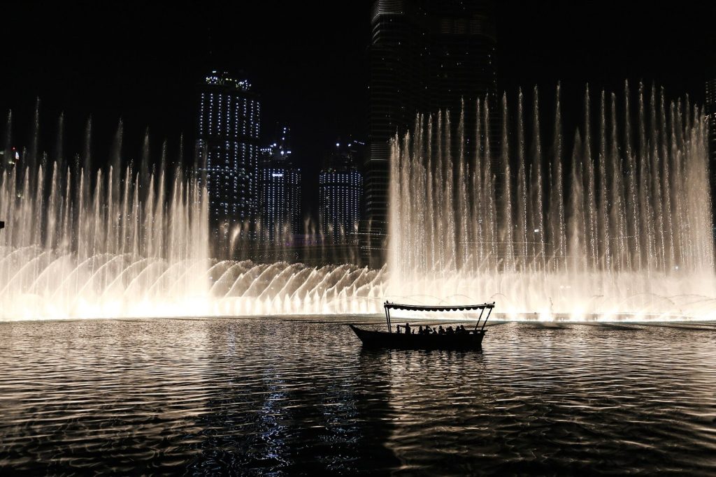 Espectáculo de la Fuente de Dubái de noche con una barca en el lago