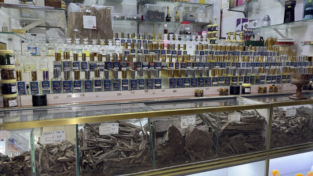 Tienda de perfumes árabes con frascos de attar y trozos de madera de oud