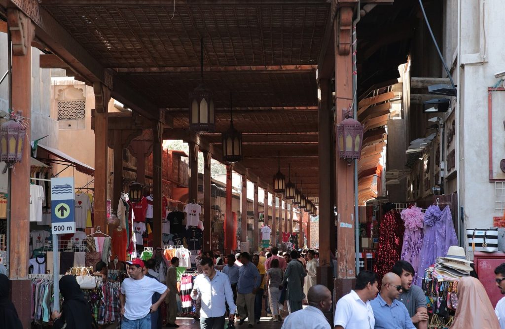 Callejón cubierto del zoco textil de Bur Dubai con ropa y telas colgadas